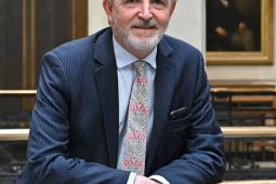 Image of a man in a suit smiling to camera